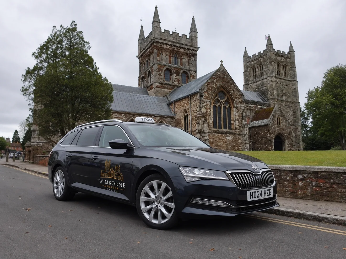 Branded Wimborne Minster taxi with Wimborne Minster in the background
